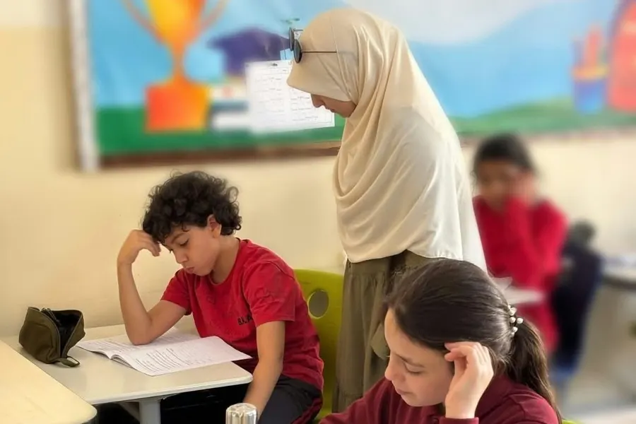A BHA teacher working one-to-one with students at their desks