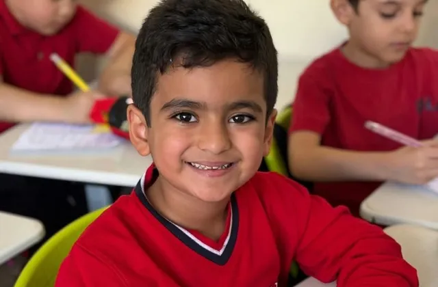 An elementary pupil writing at his desk